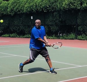 Derrick Milligan playing tennis.