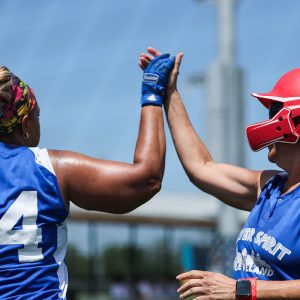 Two softball athletes high-five.