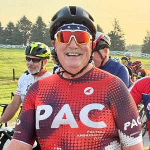 Mark Smith smiles broadly while waiting for a cycling race he is participating in to start. 