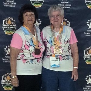 Bonita Robbins and her women's doubles bowling partner pose with their medals at the 2025 National Senior Games.
