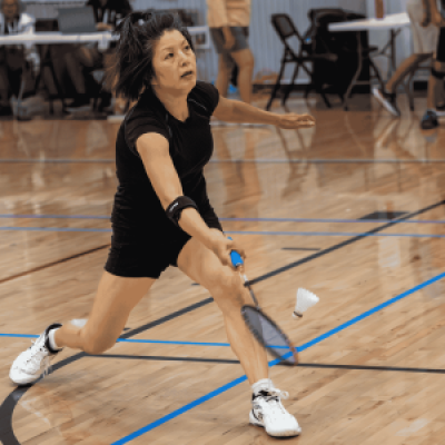 A badminton athlete reaches for a hit during a match at the National Senior Games.